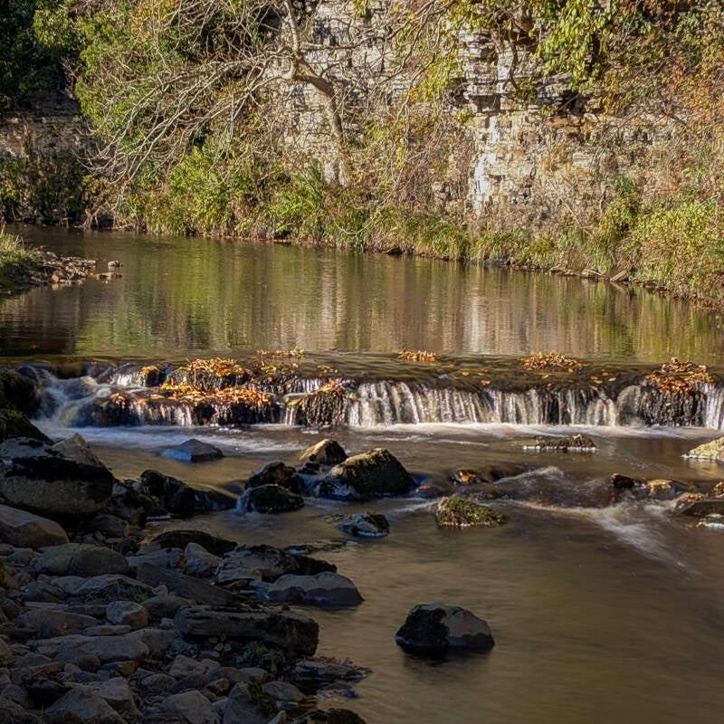 Narrow stream of water tumbling through carved stone channels in the Sleightholme Beck valley.