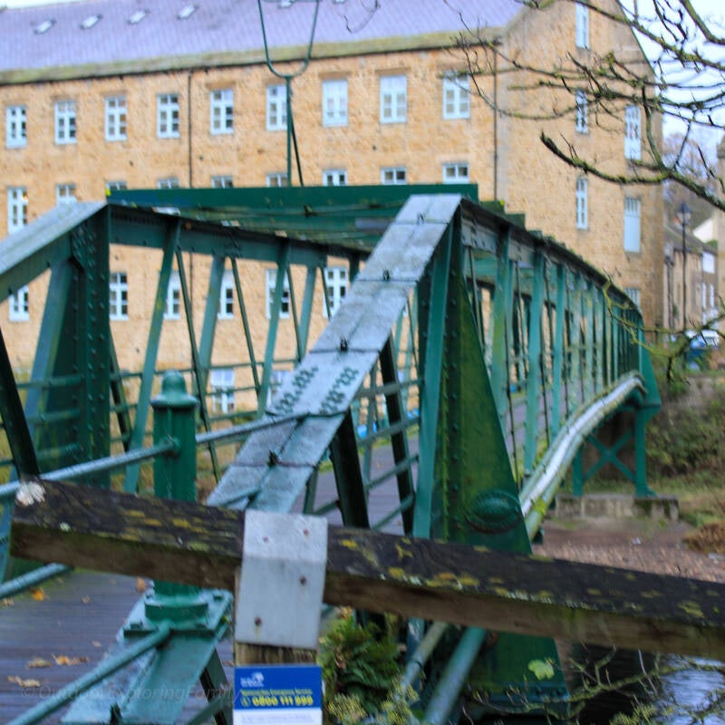 Wooden deck and green iron sides of Thorngate Bridge, the footbridge linking Barnard Castle and Startforth.