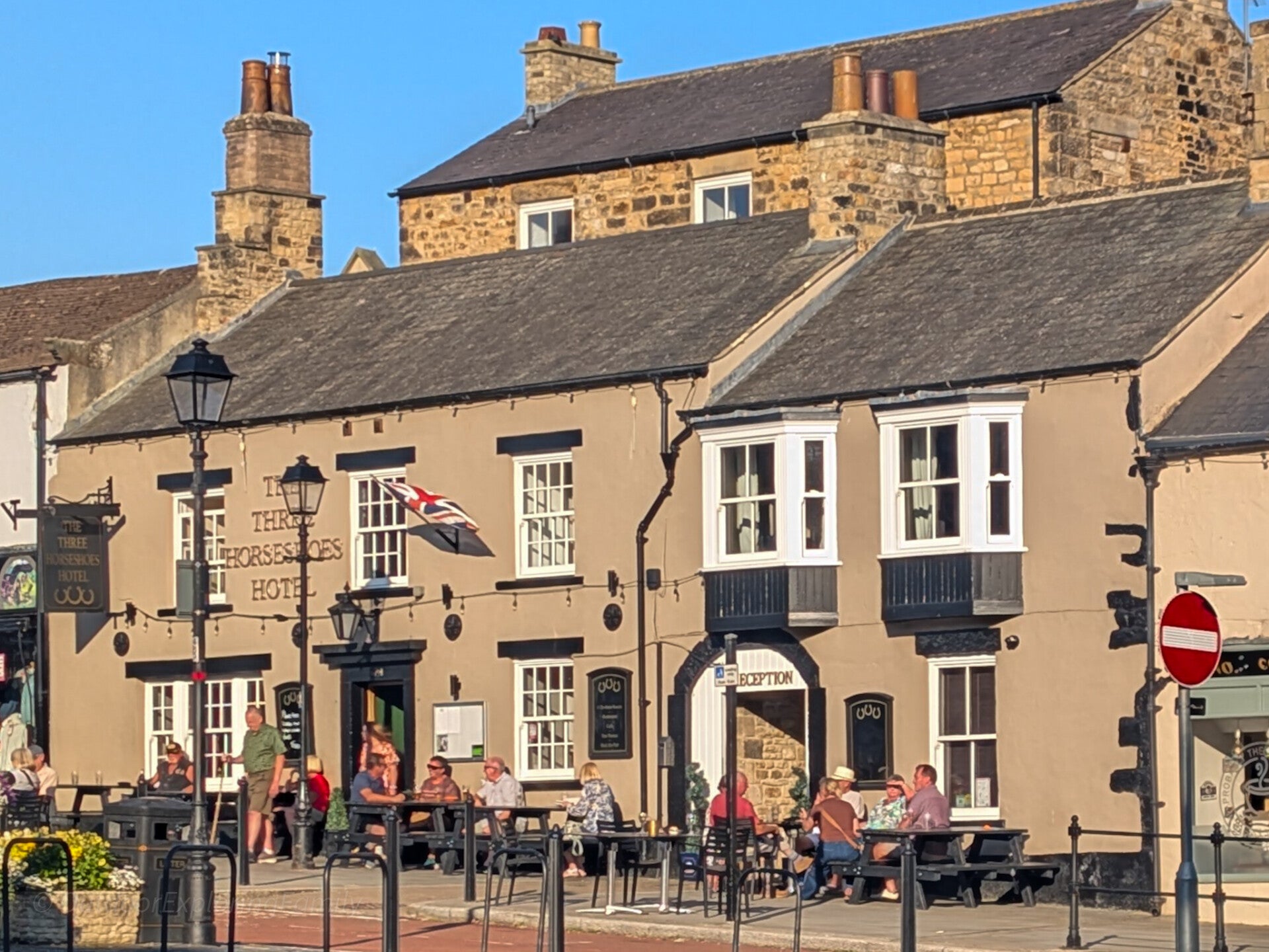 The Three Horseshoes Hotel on Galgate in Barnard Castle, with people sitting at outdoor tables in front of the historic building.