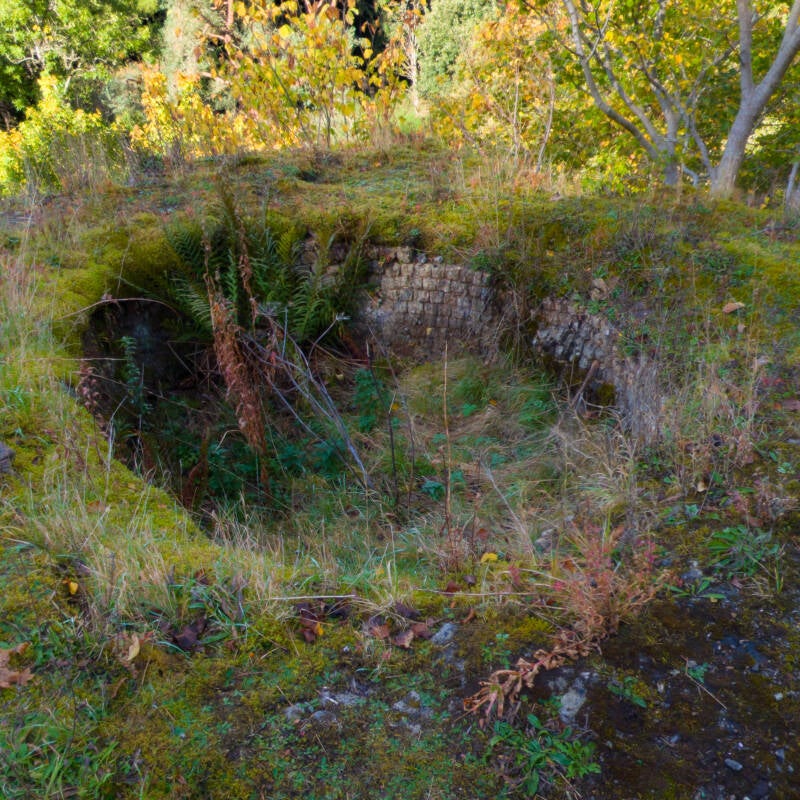 Stone remains at the top of one of the Skears lime kilns, partly overgrown beside the upper path.