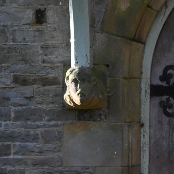 Entrance porch of the London Lead Company School in Middleton-in-Teesdale with a carved stone head beneath the timber support