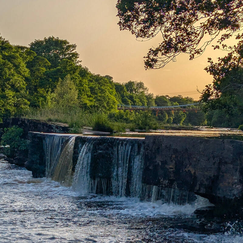 Fish weir on the River Tees with Whorlton Bridge in the distance