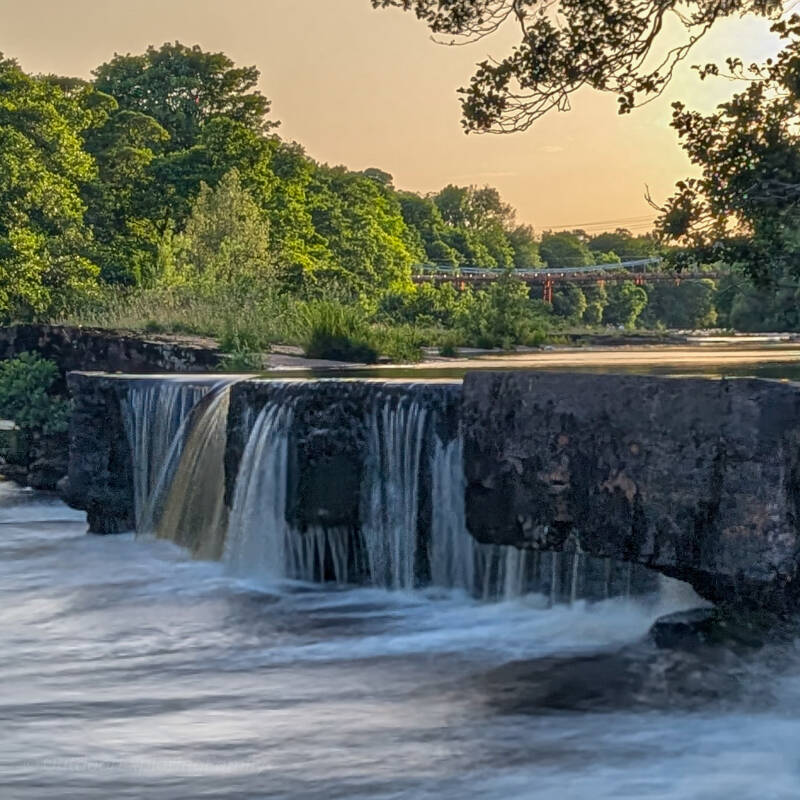 Old fish weir on the River Tees with Whorlton Bridge in the distance