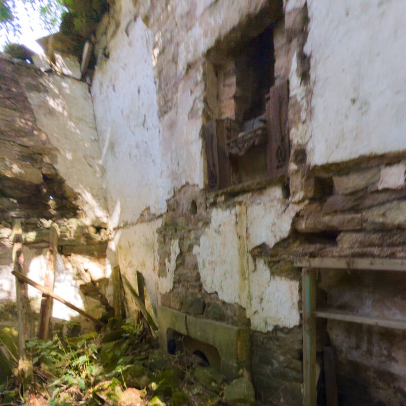 Interior of the smaller ruined house at Yew Tree Farm showing surviving plaster, stonework and old fireplace fittings