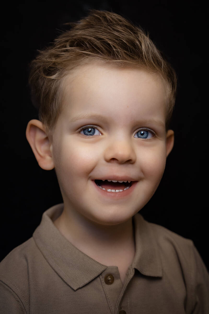 Kind portret foto jongetje blauwe ogenzwarte of witte achtergrond 