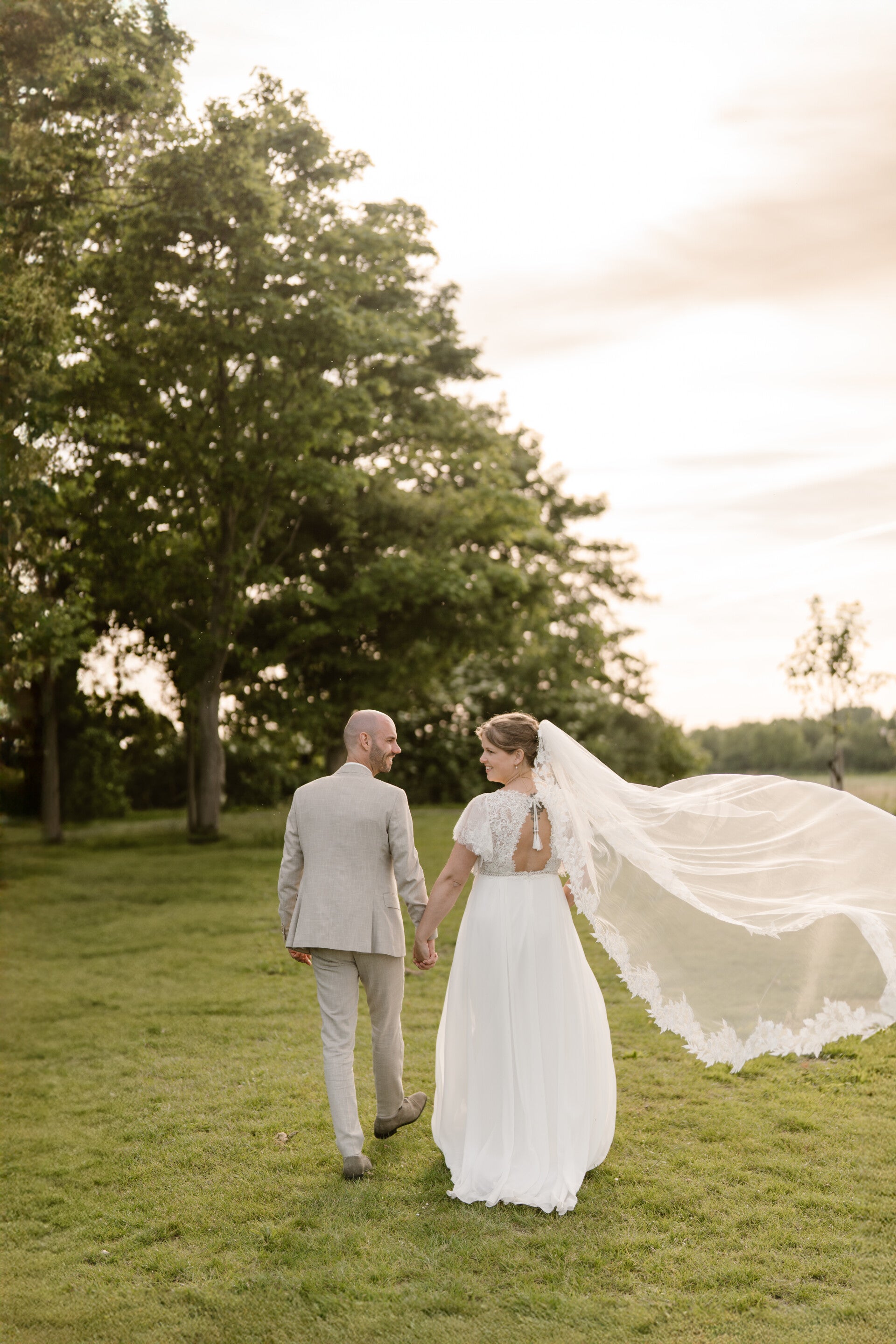 Getrouwd stel in pak en jurk lopen hand in hand