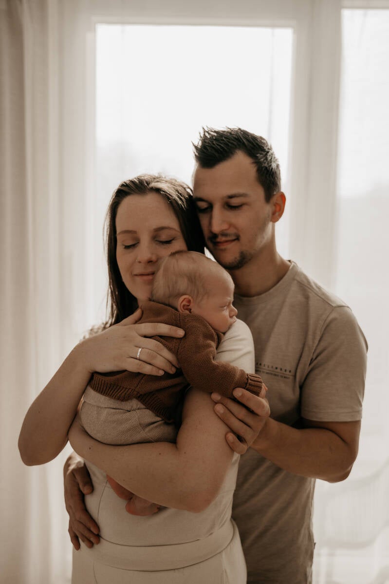 Newbornshoot gezin slaapkamer bed thuis baby handen details warm