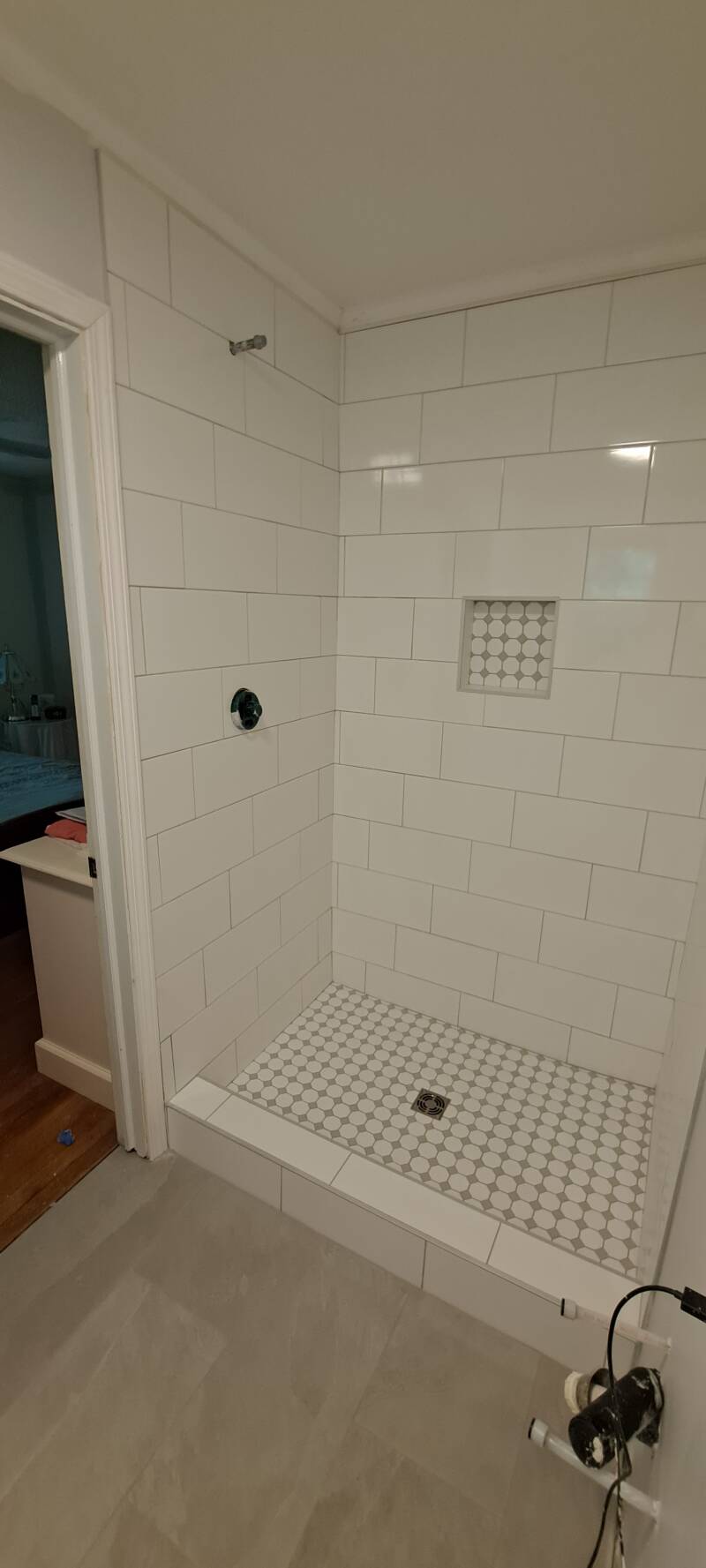 Completed custom tile shower featuring classic white subway tile, a hexagon-tile shower floor, recessed niche, and clean modern finish installed by New Looks 4 Home LLC in Upstate South Carolina