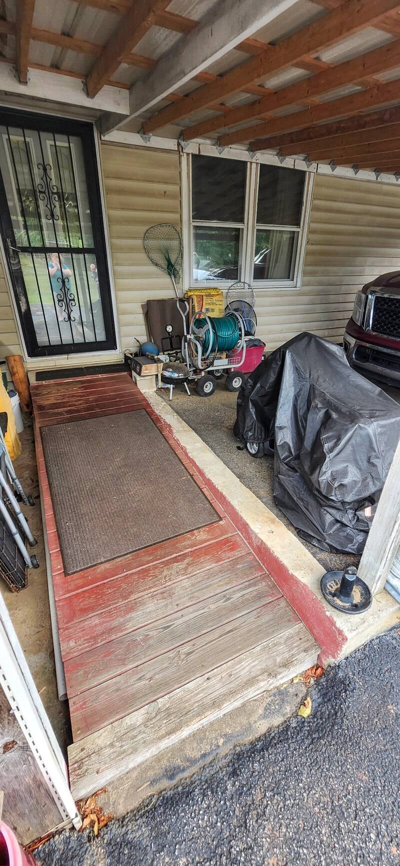 "Before photo of an old, unsafe wooden entry ramp with uneven boards and rot, showing the area prior to a custom handicap-accessible ramp rebuild by New Looks 4 Home LLC in Anderson SC.