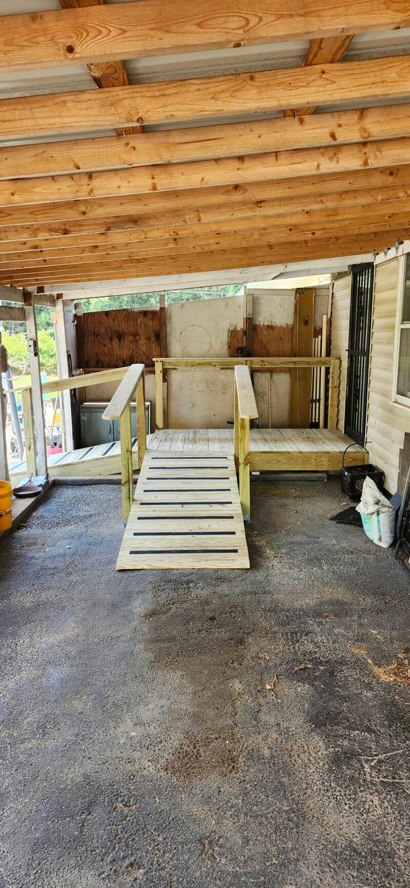 Wide-angle view of the completed handicap-accessible ramp featuring a spacious landing, secure handrails, and durable pressure-treated construction designed for safe mobility access.