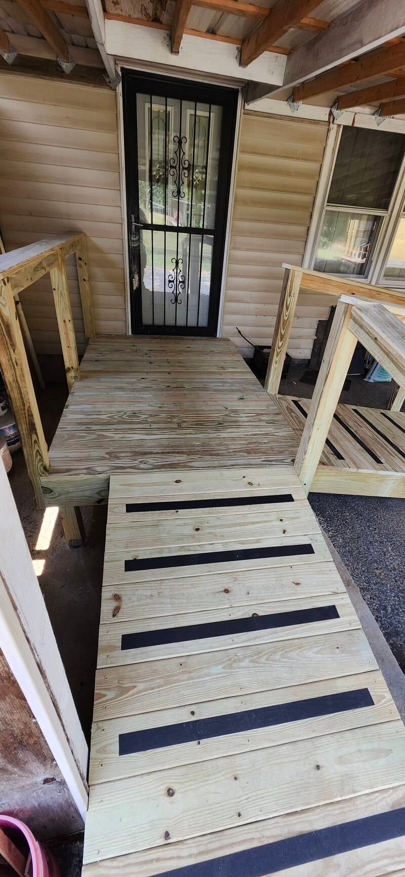 After photo of a newly built custom handicap-accessible ramp with pressure-treated lumber, safety grip strips, and sturdy handrails installed by New Looks 4 Home LLC."