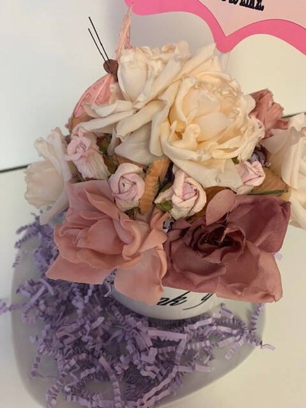 Mug with artificial flowers.