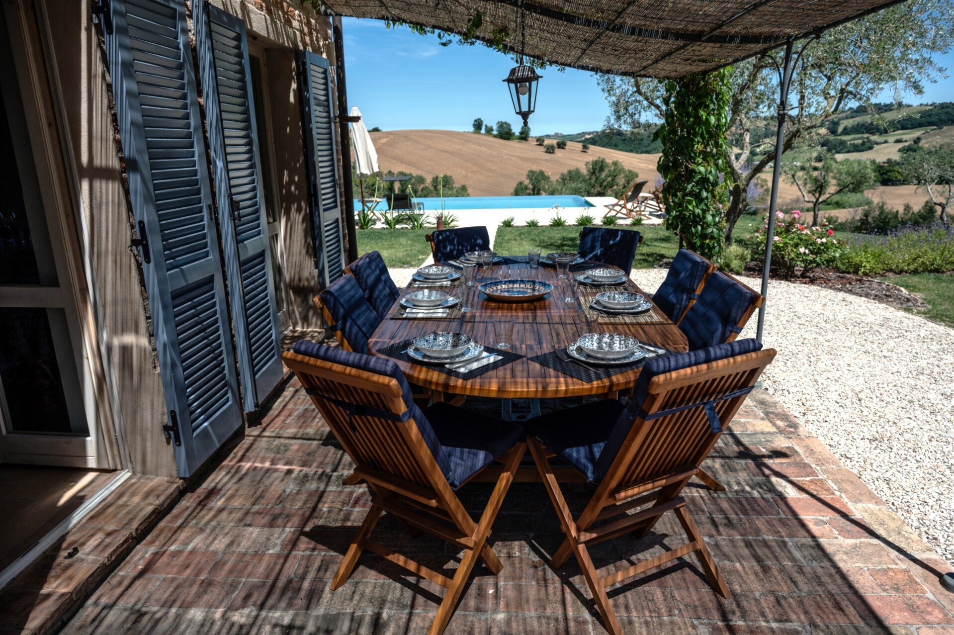 Outdoor dining table with a direct view of the garden and the Ostra Vetere medieval skyline