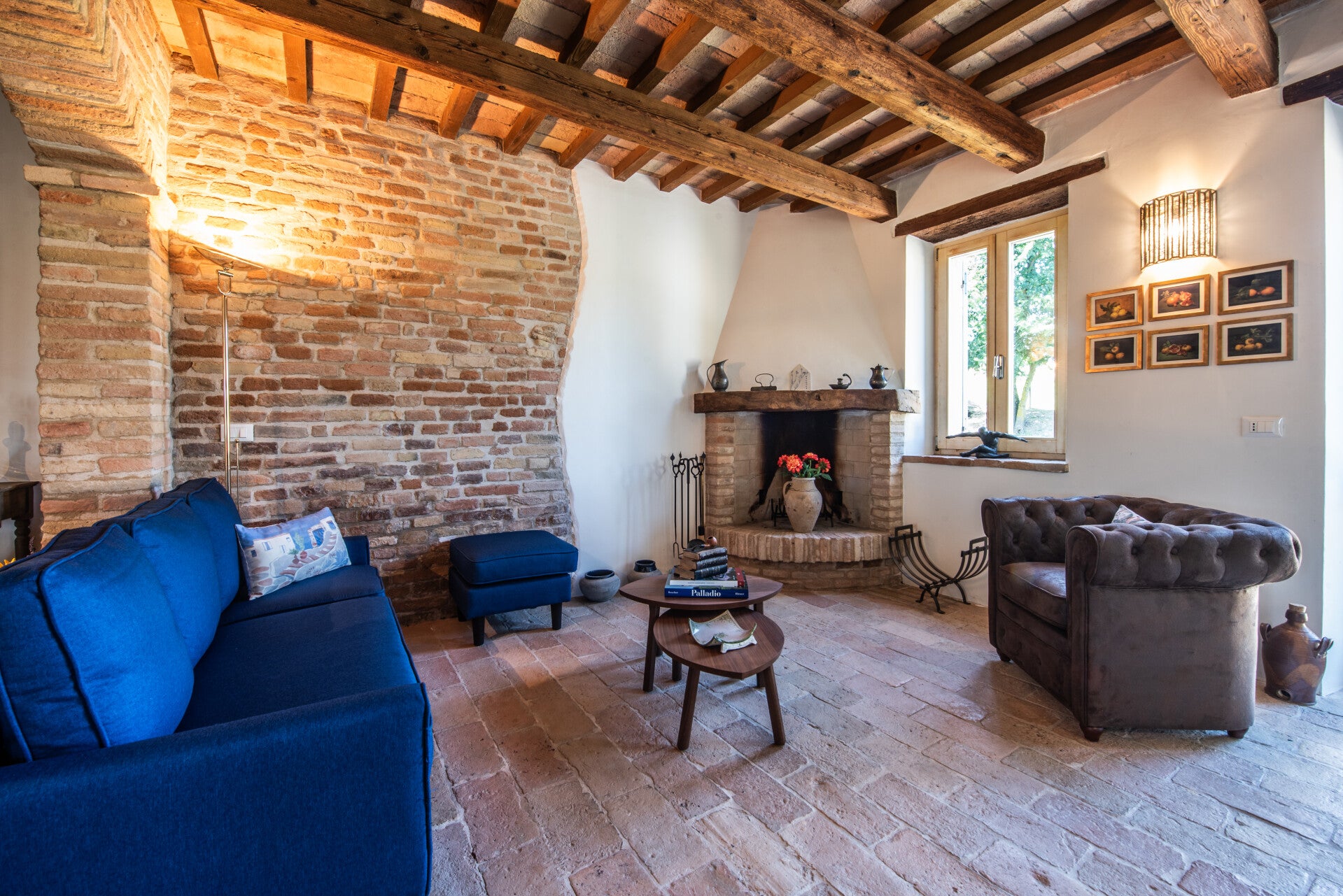 Ground floor living room featuring two stunning original brick arches and historic terracotta flooring, reflecting the authentic character of Casale Oleandri