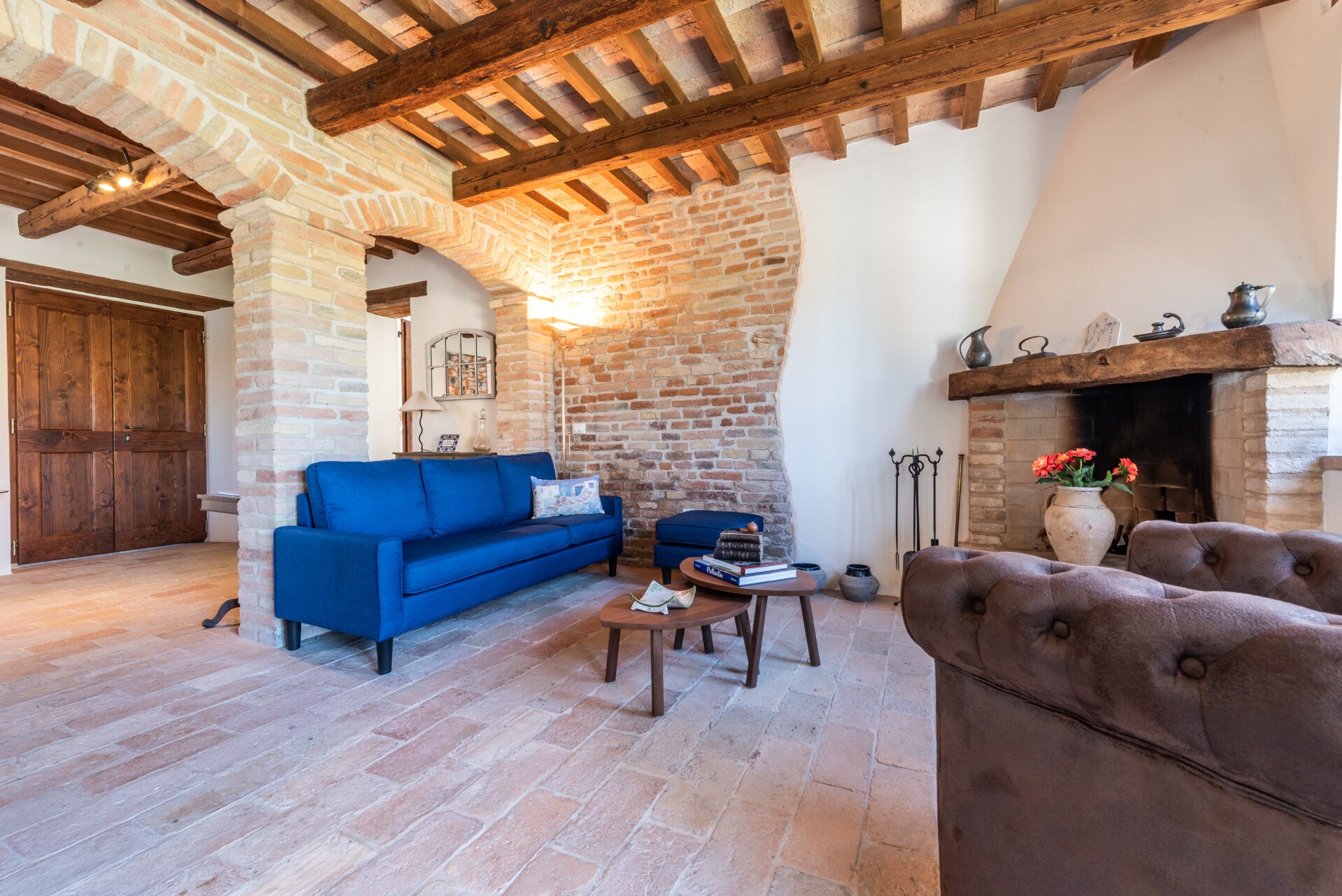 Downstairs living room, where the striking exposed brick accent wall meets the warmth of a traditional corner fireplace