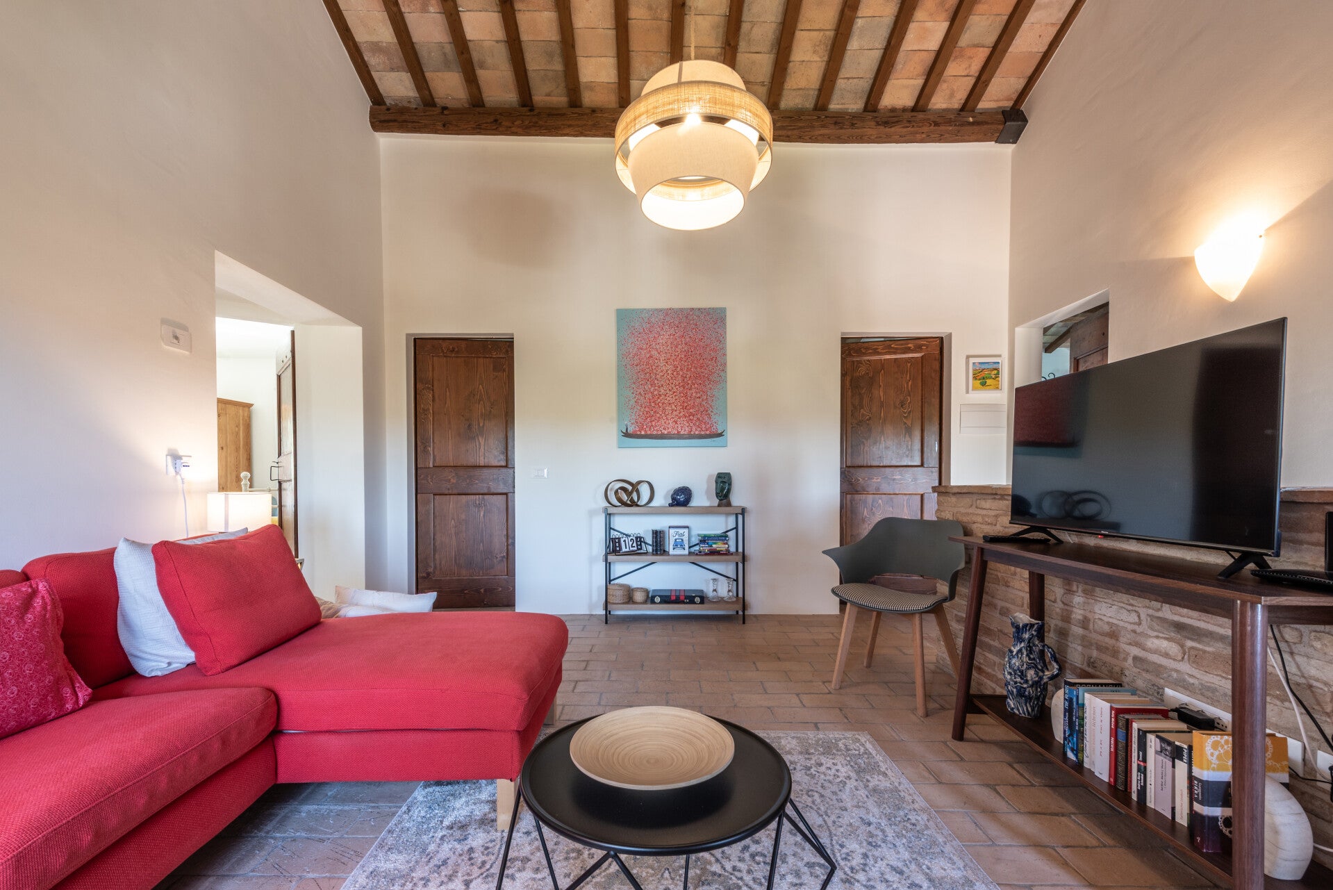 Living room upstairs: a plush, vibrant red L-shaped sofa that invites you to lounge, read, or enjoy quiet conversation