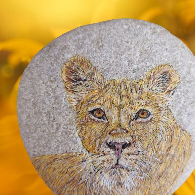 Totemdier Leeuwin geschilderd op steen.