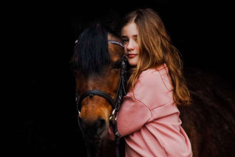 A very cute picture of a pony and a little girl, showing the equine bond
