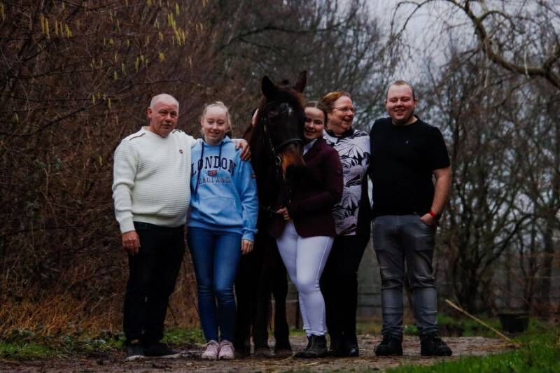 A picture showing a family and their horse