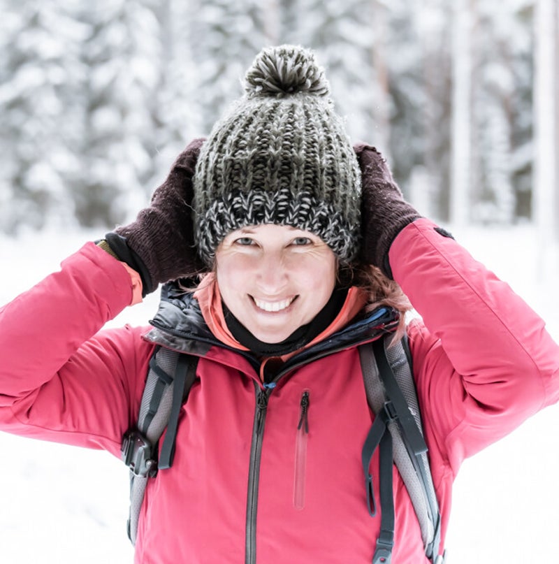 het gezicht van merlijn arina photography terwijl ze in zweden een hike maakt. met dik vest aan, een rugzak op en een haarband op het hoofd.