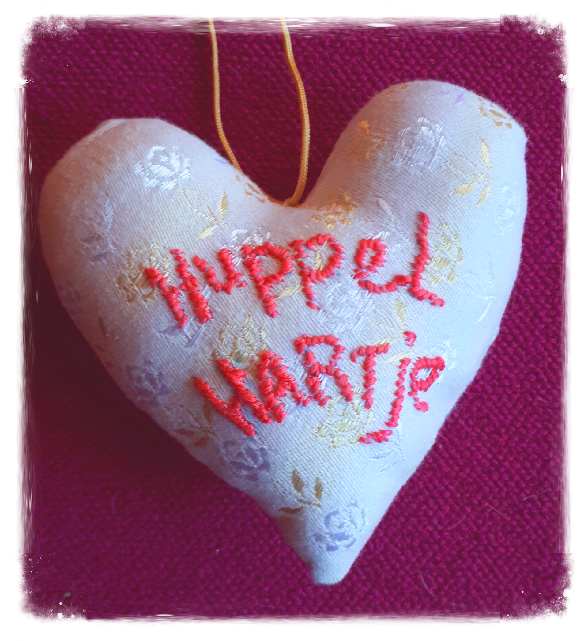 Een hartje van textiel met tekst: Huppel hartje. Waar wordt jij blij van? 