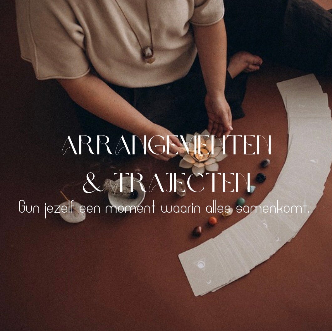 Een vrouw die zit met kristallen, palo santo, en affirmatiekaarten voor haar, met de tekst 'arrangementen'. 