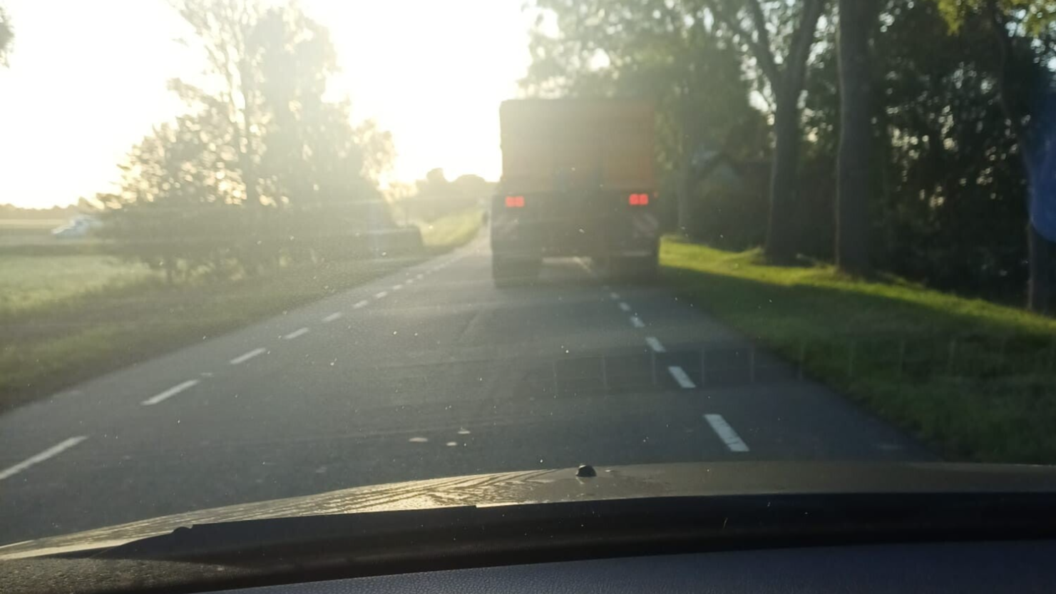 Een auto die rustig achter een tractor rijd op een landweg voor een moment van rust