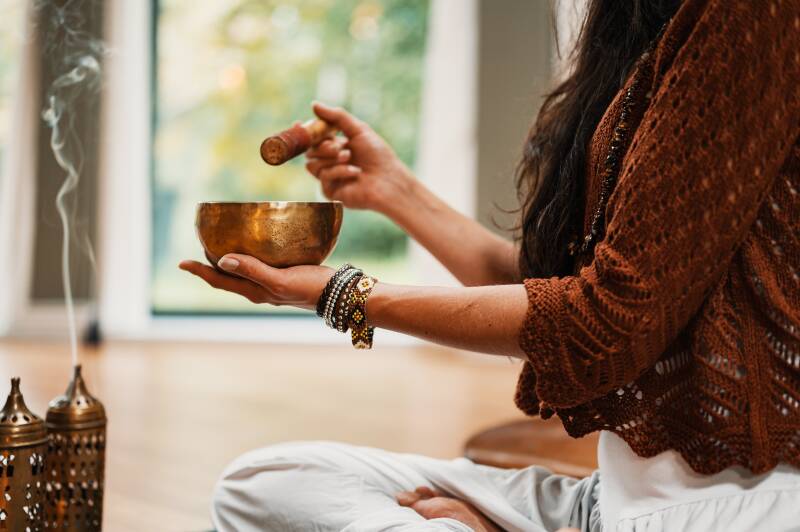 femme utilisant un bol tibétain et de l'encens