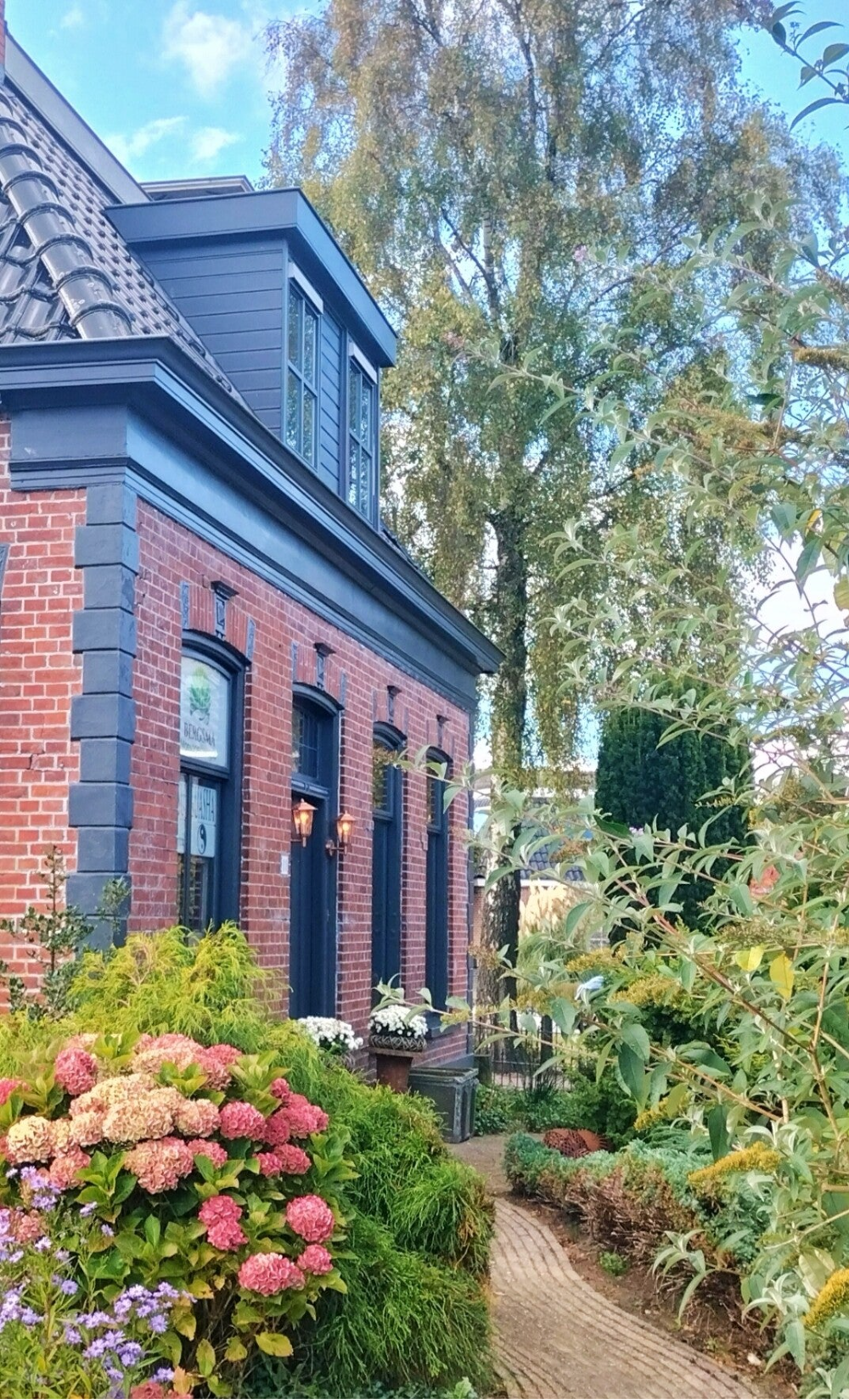 Praktijkpand van Bergsma Balans in Augustinusga, met tuin en ingang