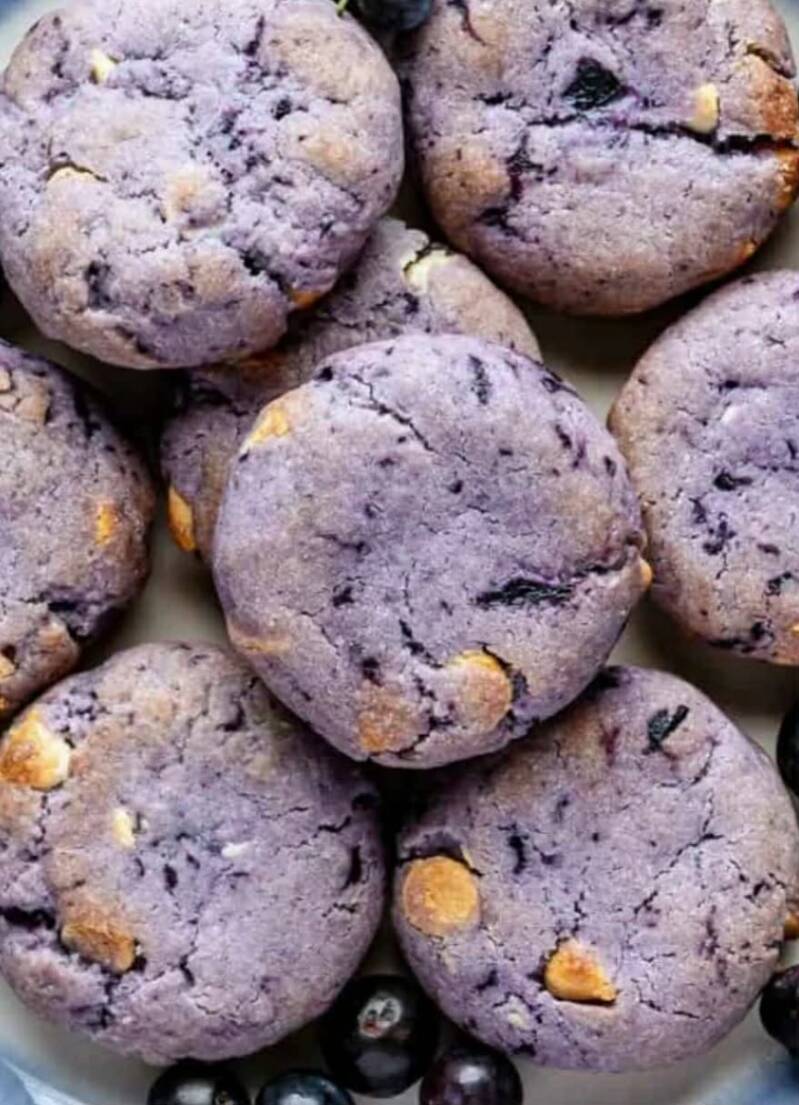 Butter Crisco blueberry cookies with white chocolate chips stacked and showing purple berry streaks