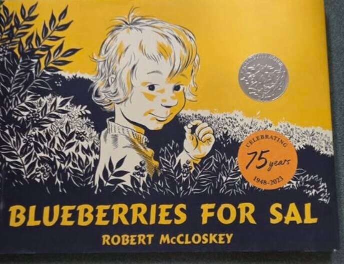 75th anniversary edition of Blueberries for Sal by Robert McCloskey showing illustrated cover of little girl Sal picking blueberries in bushes. Caldecott Honor seal and "Celebrating 75 years sticker. Classic educational picture book gift for grandkids.