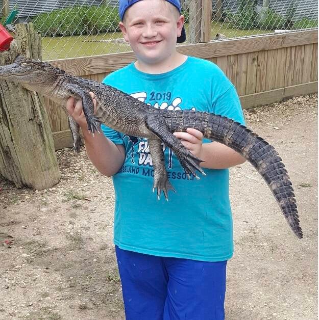 Boy holding a young alligator at Kliebert's Gator Farm