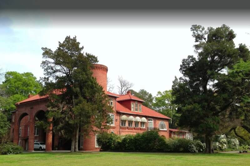 Layton Castle red brick exterior with turret and moss-draped oak trees in Monroe, Louisiana