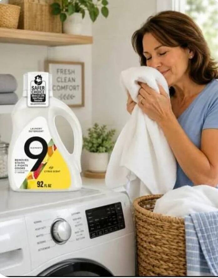Woman smelling a clean towel next to 9 Elements laundry detergent
