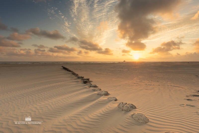 Paaltjes in het zand bij Hollum – Zonsondergang op Ameland