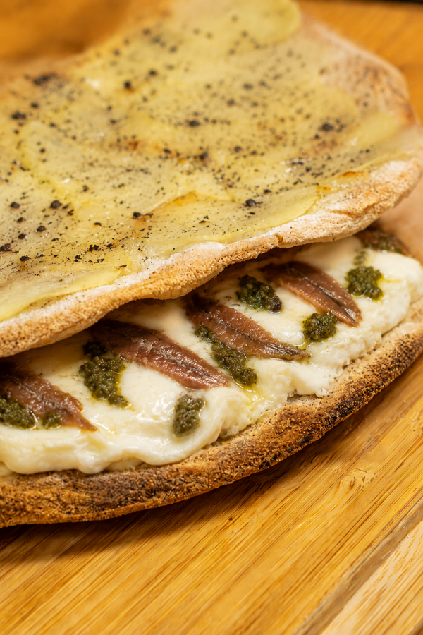 160 Pizza farcita con acciughe, burrata, pesto di capperi e polvere di olive nere