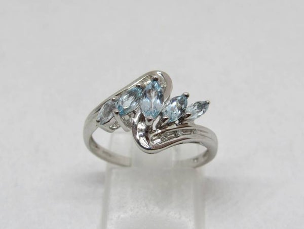9 Karaat. Ring met 5x blauwe topaas en 6x diamant (ca. 0.04 ct.). Maat: 17.5. Nr:18/398.