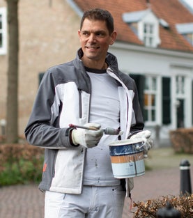 Portret van schilder met emmer en kwast voor statig pand, voorbeeld van professioneel buitenschilderwerk