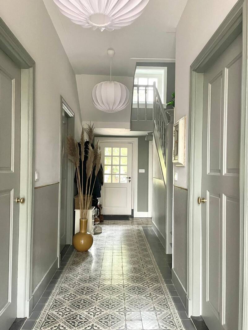 Binnenschilderwerk in monumentale hal met trap in rustige grijstinten en klassieke details