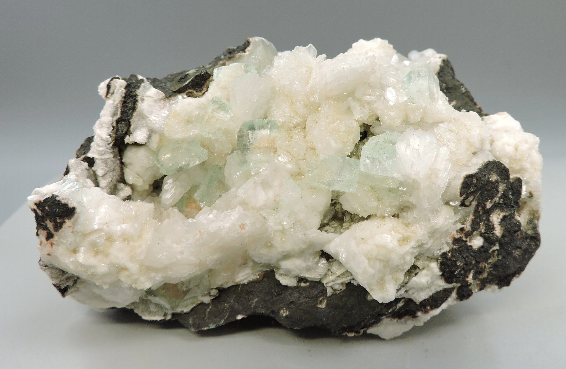 Green apophyllite with prehnite and stilbite on matrix from India – cabinet size