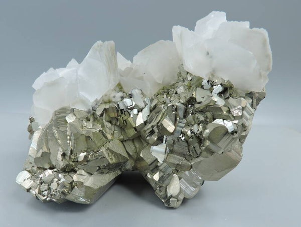 Pink fluorescent calcite on pyrite from Kosovo – cabinet size