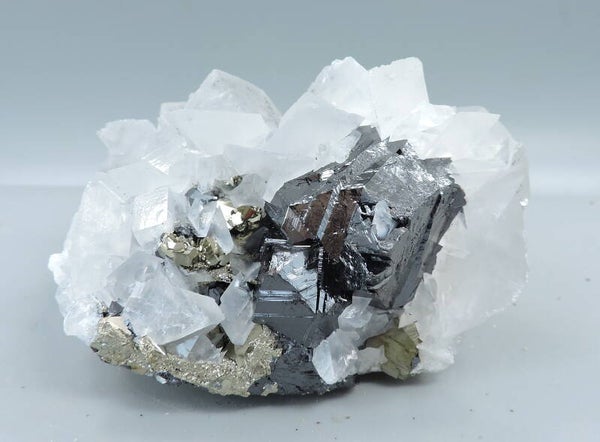 Pink fluorescent calcite (LW) and pyrite on sphalerite from Kosovo – small cabinet size