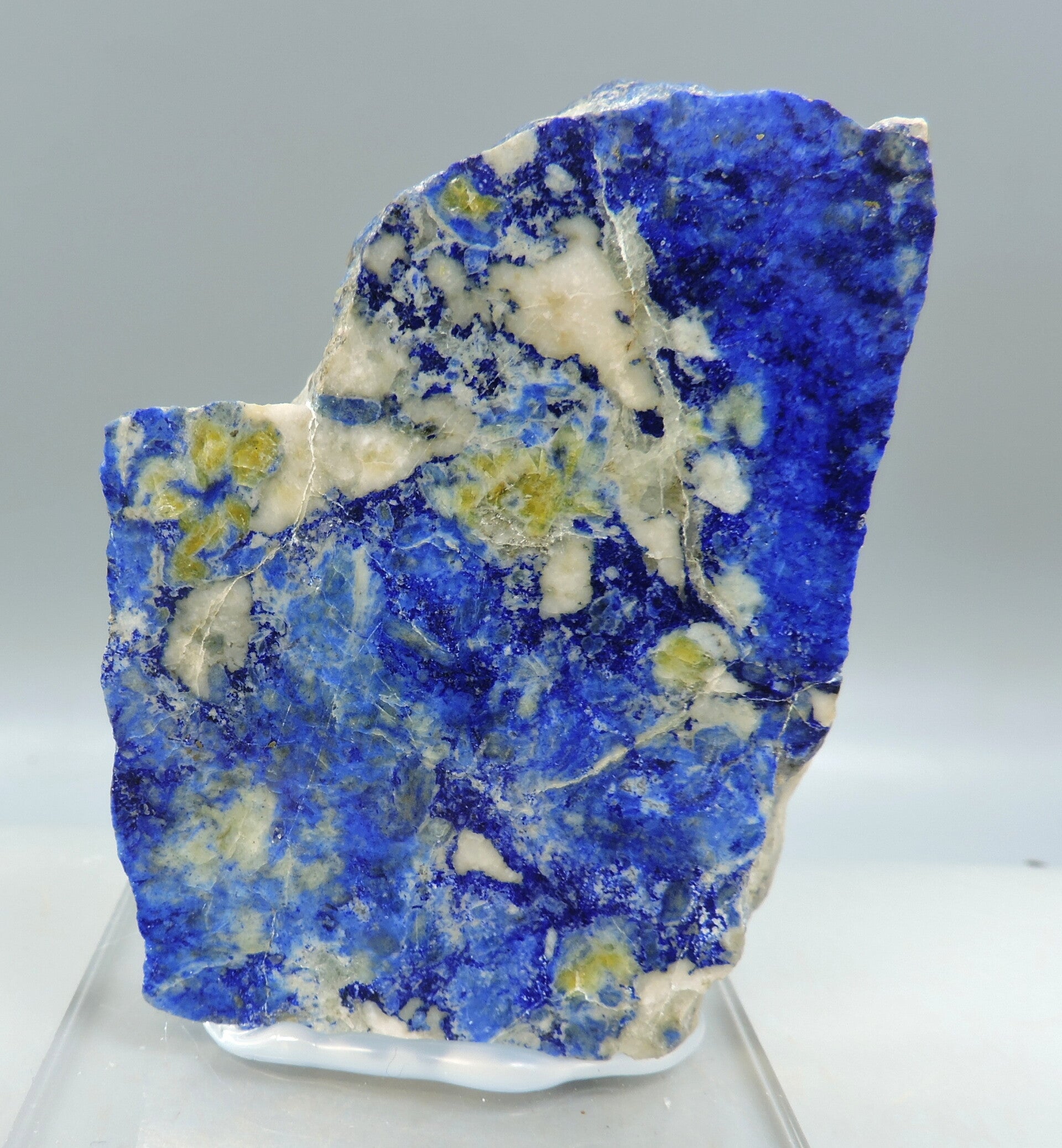 Polished lapis lazuli with orange fluorescent calcite from Afghanistan – miniature