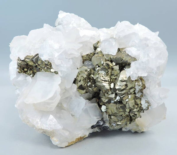 Pyrite on pink fluorescent calcite from Trepca, Kosovo – cabinet size