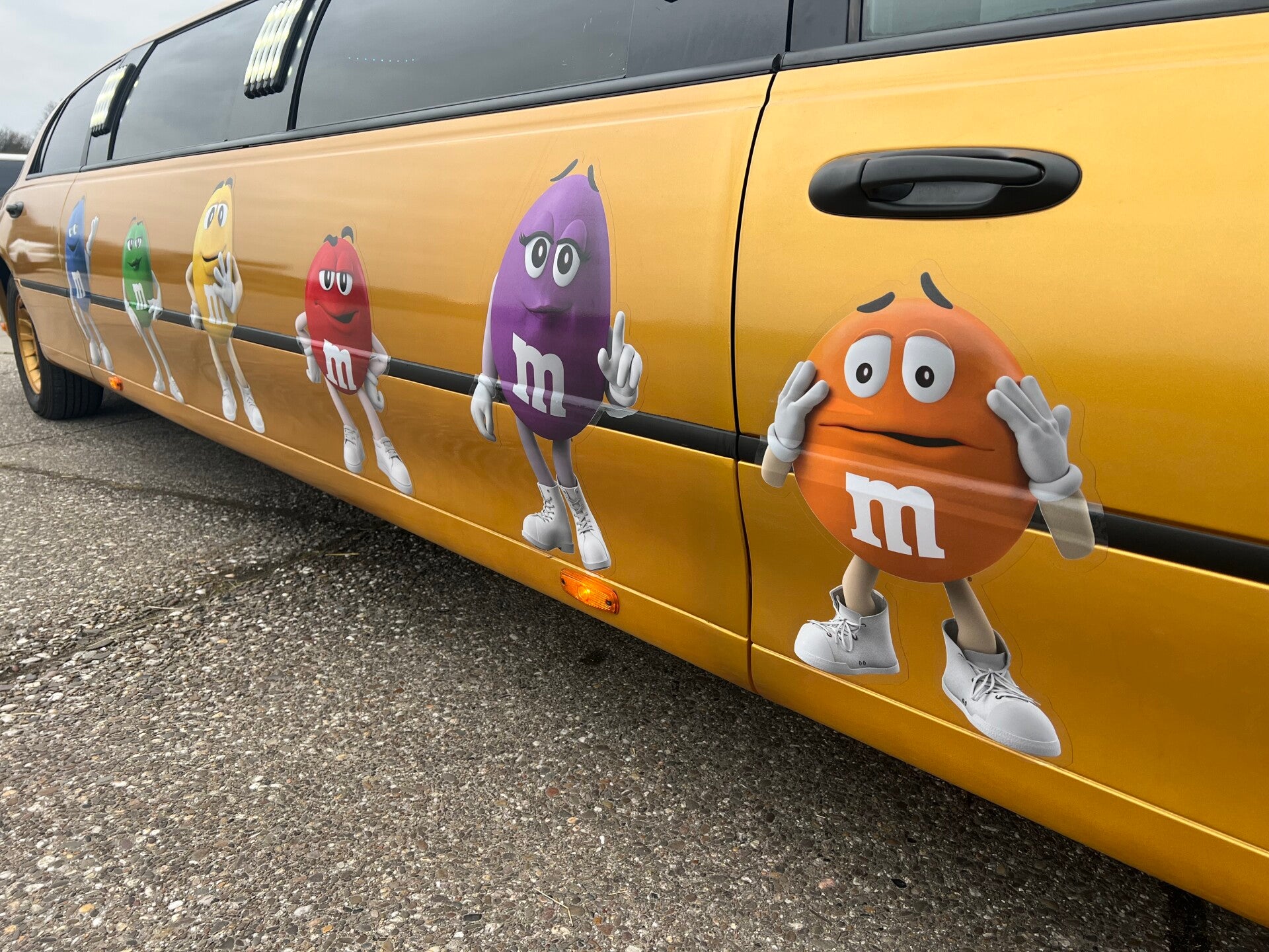 M&M bestickering op gouden limousine