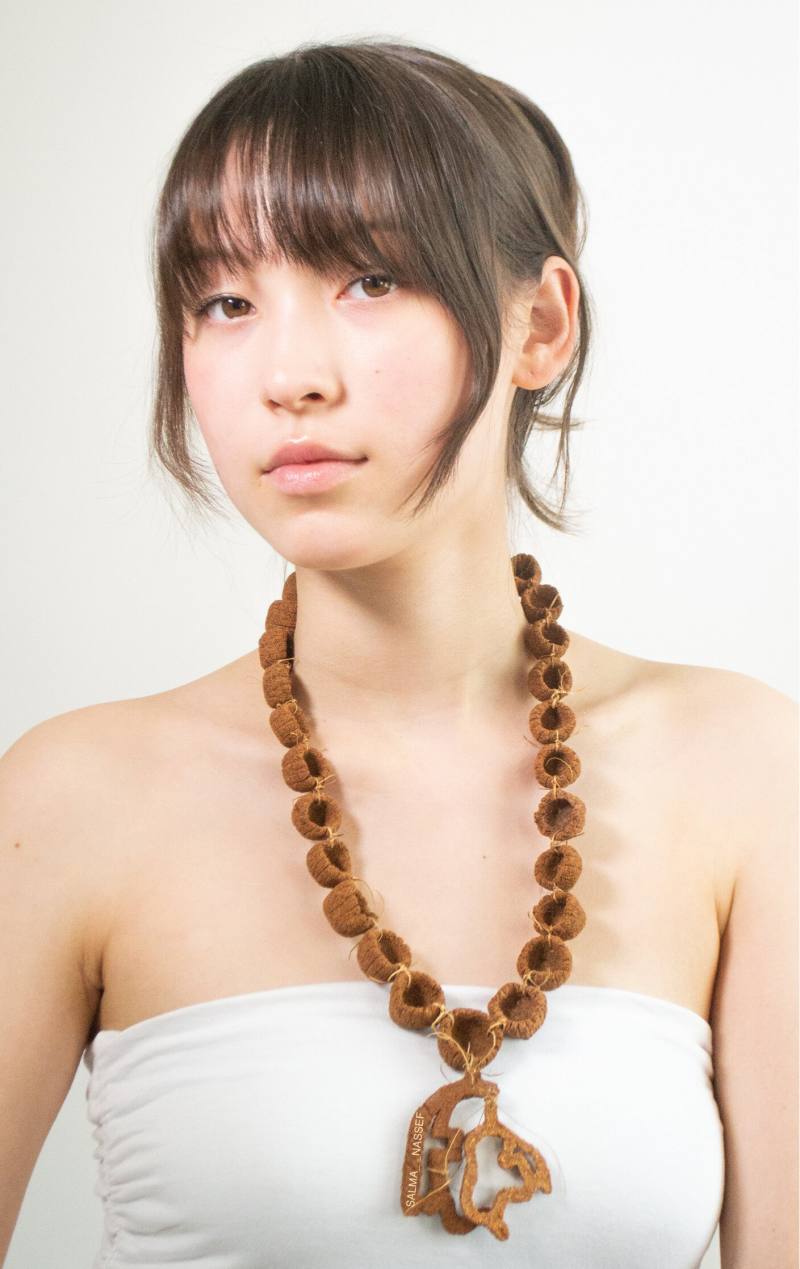 Sustainable hand sculpted necklace which is brown and one hundred percent natural and worn by model