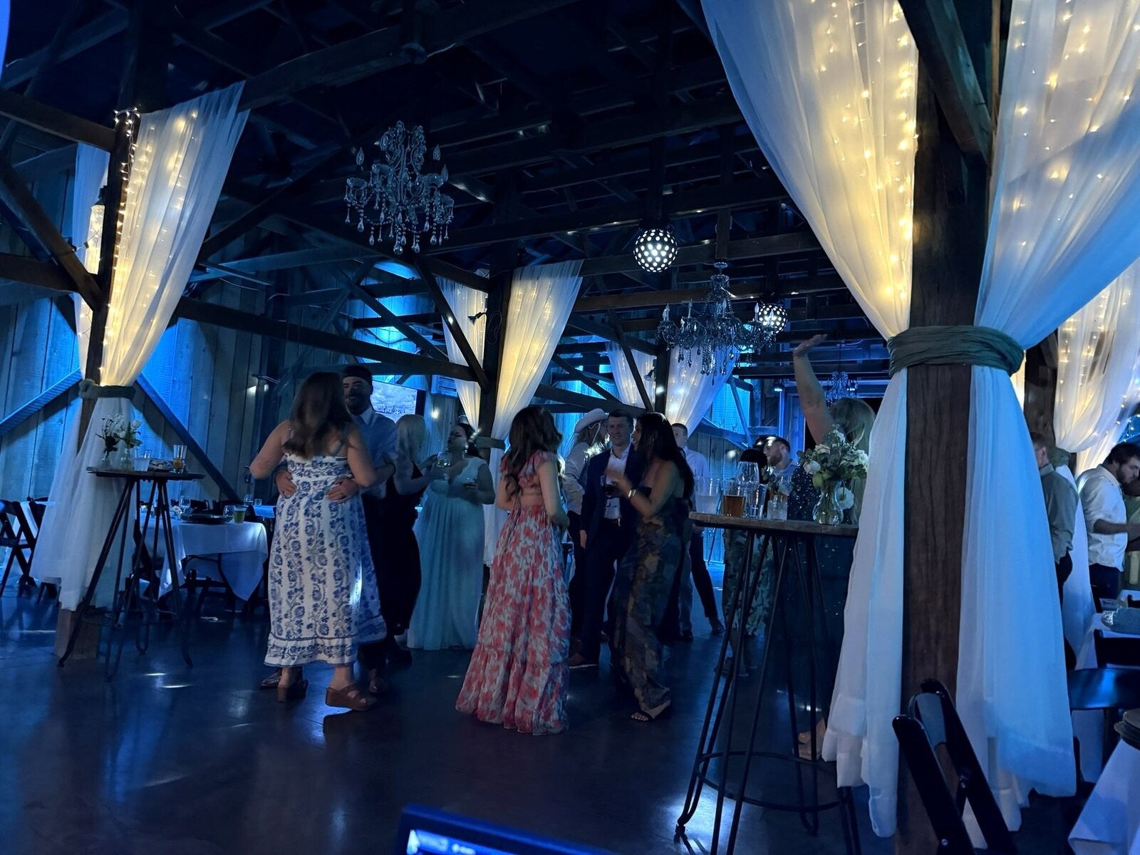 Wedding reception dancing under string lights in the barn at Farmer & Frenchman
