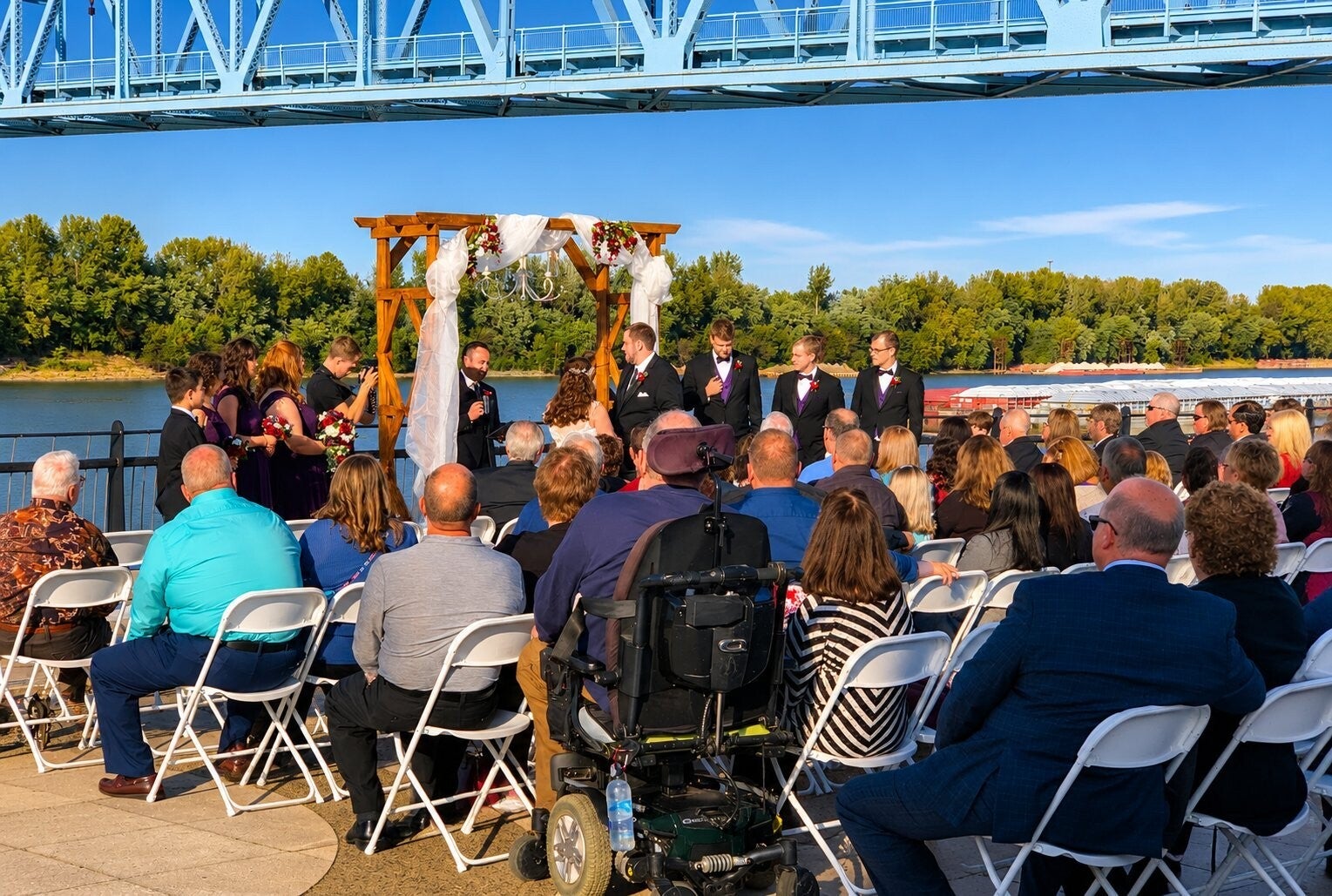 Outdoor wedding ceremony at RiverPark Center in Owensboro, Kentucky, with the Blue Bridge over the Ohio River