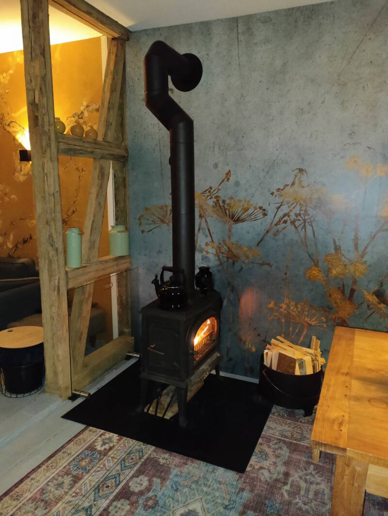 De houtkachel staat lekker aan in de woonkamer