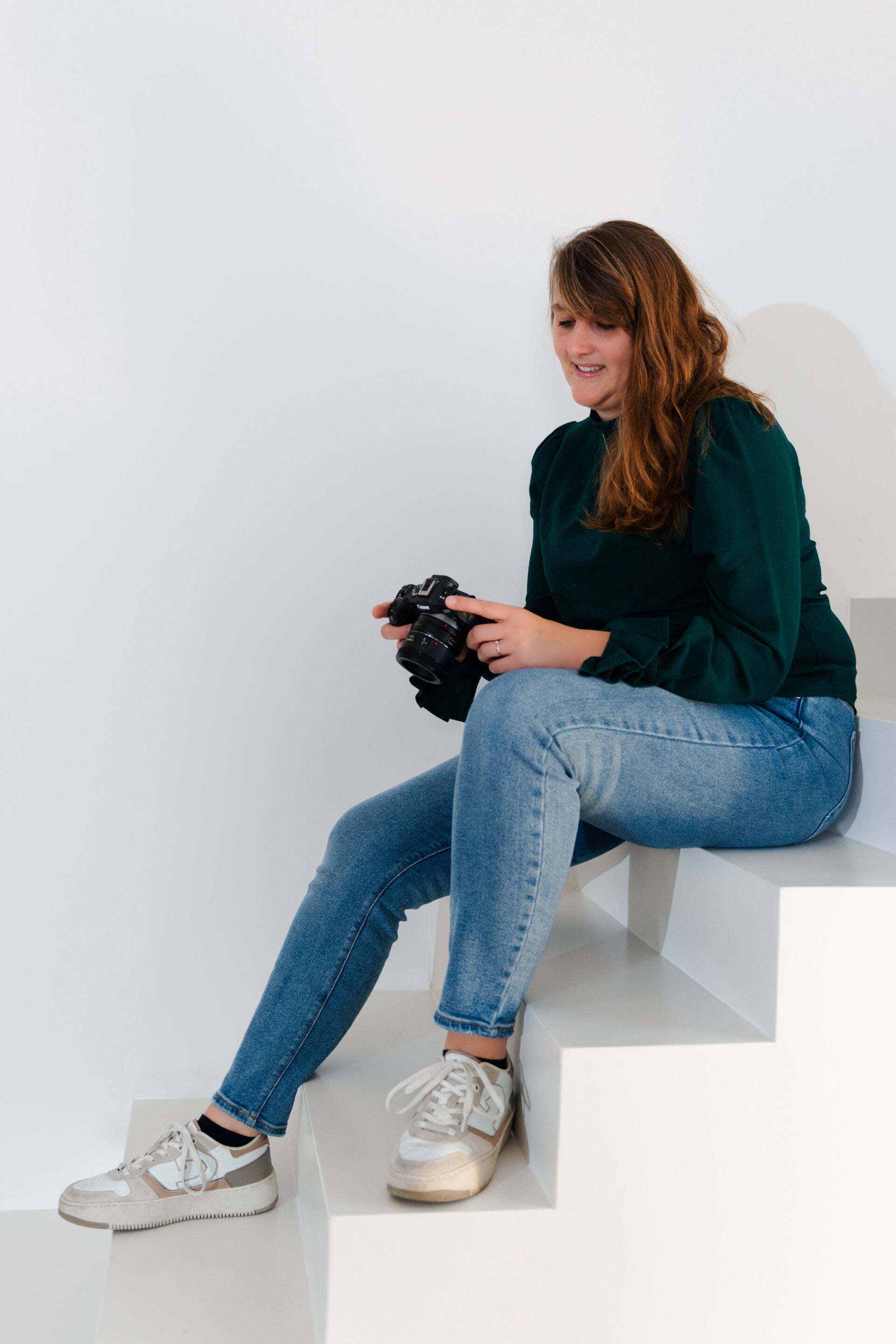 Fotograaf zittend op een trap kijkt naar de camera